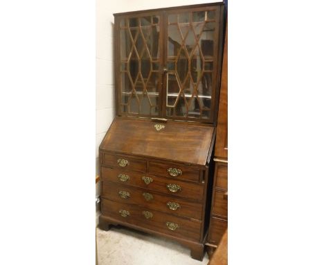 A George III mahogany bureau, the sloping fall opening to reveal a fitted interior, over two short and three long drawers, ra