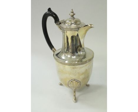 A late Victorian silver water jug of urn form, raised on three shell decorated splayed feet (Sheffield 1891), 16.62 oz includ