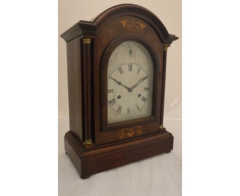 A circa 1900 mahogany and marquetry inlaid cased mantel clock, the German eight day movement with silvered arch dial and Roma