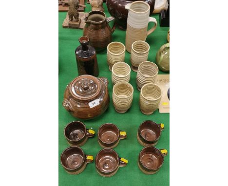 A collection of studio pottery by Colin Pearson to include casserole dish in brown glaze, jug and six mugs, six cream ground 