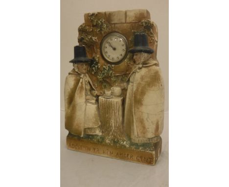 A plaster cased clock decorated in high relief with two Welsh ladies taking tea inscribed "Adcofion yr hên amser gynt"