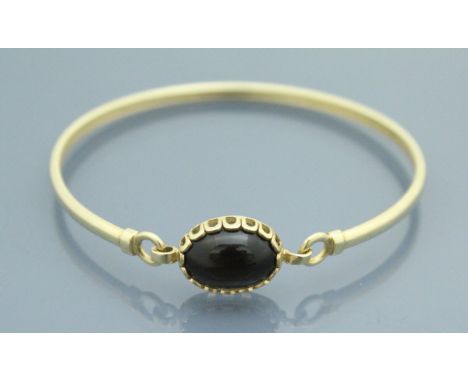 A 9 carat gold cabochon set bangle