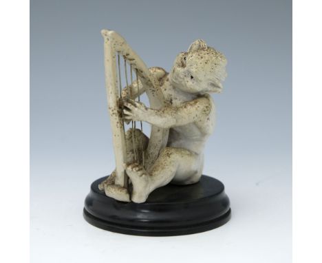 Robert Wallace Martin for Martin Brothers, a stoneware musical imp figure, circa 1893, modelled playing the harp, speckled cr