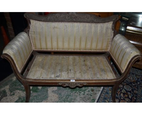 A late 19th/early 20th century salon sofa, the cresting rail carved with a mask of a Green Man surrounded by trailing foliage