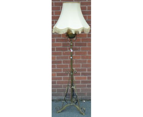 A brass standard oil lamp, converted for electricity, scroll supports with wrought iron detailing, early 20th century