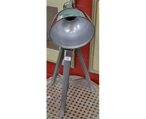 A modern chrome plated industrial style tripod lamp