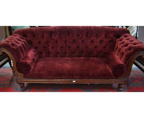 A William IV rosewood scroll end sofa, deep buttoned stuffed over upholstery, the substantial frame carved with acanthus, tur