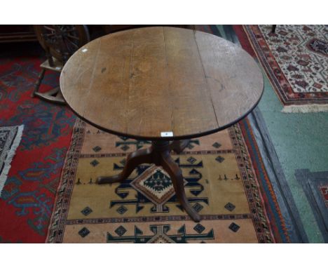 A George III oak circular tilt top tripod table