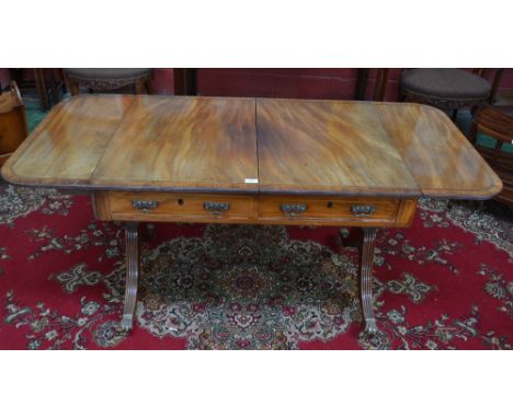 A Regency mahogany rounded rectangular sofa table, crossbanded reeded top above a pair of frieze drawers, blind to verso, out