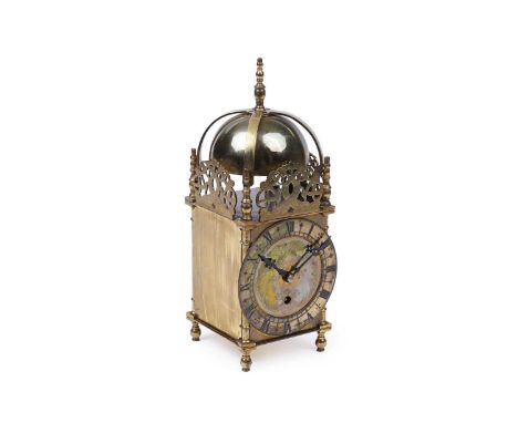 An early 20th Century brass lantern clock, the dome top within pierced and dolphin engraved side panels, over dial with engra
