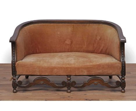 A carved oak tub sofa, c.1920's with stuffover seat pad and foliate carved frame, 124 x 65 x 71cms high.