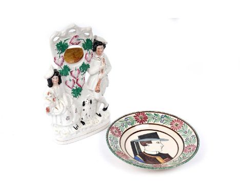 A Victorian Staffordshire pocket watch-holder flatback figure group, 32cms high; and a Quimper hand-enamelled circular dish. 