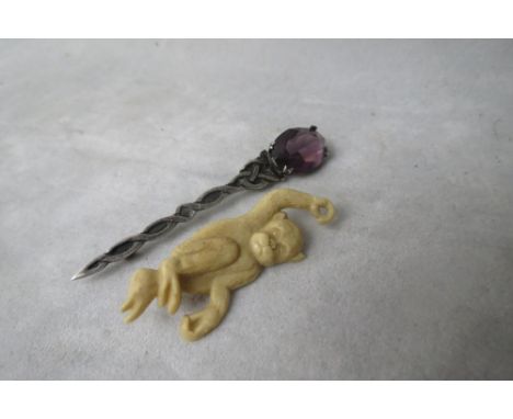 A silver pin brooch set with an amethyst coloured paste stone with Celtic decoration, hallmarked for Cook, Holland & Co, Birm