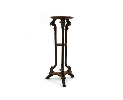 An 19th Century torchere, the tripod form columns having carved rams head detailing, central shelf and platform base terminat