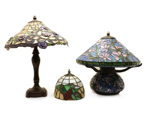 A Tiffany style table lamp, the shade decorated with stylised flowers, 51cm high, together with a squat example, 43cm high an