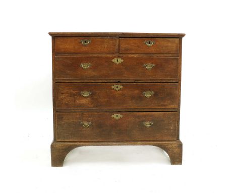 A George III oak chest of drawers, with plank top and border mouldings, engraved brass plate handles and on square bracket fe