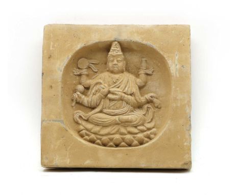 A Chinese pottery wall tile, Song Dynasty, moulded with a six armed Buddha figure in recessed circle. 28.5cm square, 4.5cm th