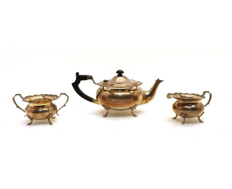 A silver three piece teaset comprising teapot, cream jug and sucrier, having scalloped border and paw feet Birmingham 1939, a