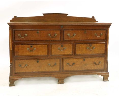 A George III Lancashire oak mule chest, with mahogany cross banded decoration, shaped raised back, hinged lid enclosing conce