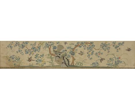 A Chinese embroidered silk panel, 20th century, decorated with peacocks standing on rocks under a blossoming tree, surrounded