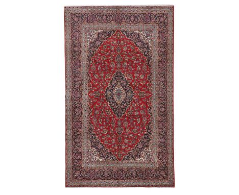 A Persian Kashan rug, 20th century, the field centred with a floral medallion, within further floral and foliate motifs, on a