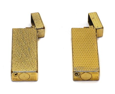 Two Dunhill lighters, one having bark effect, the other with engine turned decoration, both marked Dunhill to inside lid and 