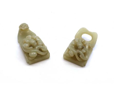 A Chinese jade two-part belt buckle, decorated with a pair of chilong, one half of the buckle terminating in a chilong head h