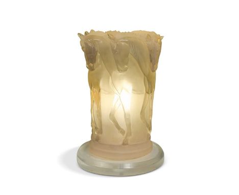 In the manner of Lalique, a lucite table lamp, the exterior modelled in relief as six horses in profile, raised on a circular