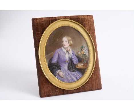 AN OVAL MINIATURE PORTRAIT  of a girl in a lilac dress with a lace shawl, in a velvet covered easel frame;  6.6"  (17 cms) hi