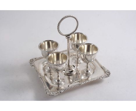 A LATE VICTORIAN EGG FRAME on an oblong base with a gadroon & foliate shell border & button feet fitted with four egg cups & 