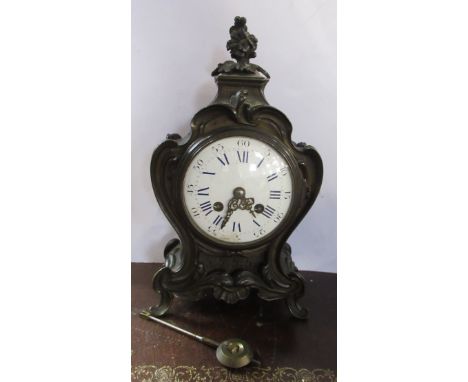 A French style brass cased mantel clock, with white enamel dial, the movement stamped H Bright Leamington, the case with scro