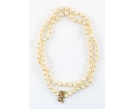 Cultured pearl necklace with a seed pearl set bow detail, cream round pearls, measuring 8.6mm in diameter, strung with knots,