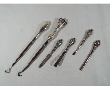 Two silver handled button hooks one with handle in the form of a crown and a four piece manicure set comprising nail files, t