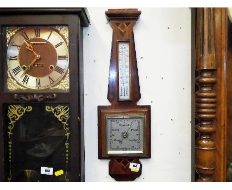 A wall mounted aneroid barometer and thermometer, Art Deco styled walnut case with geometric patterned veneers, square silver
