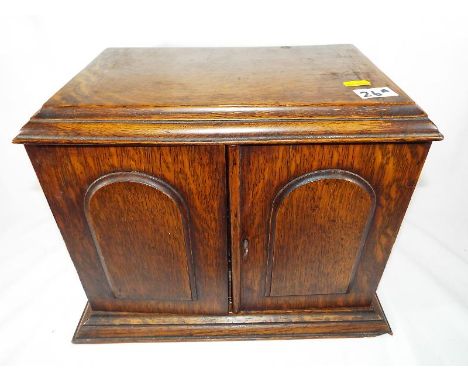 An smoker's oak cased cabinet with presentation plaque dated 1928, fitted interior with decanter and other, 30 cm x 36 cm x 2