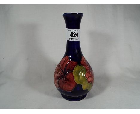 A Moorcroft Pottery solifleur vase decorated with hibiscus on a cobalt blue ground, signed to the base, 15.5 cm (high) - Est 