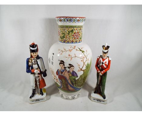 An Asian ceramic vase with floral banding, 32cm (h) and two Lafretto ceramic figurines depicting soldiers, 24cm (h) - (3)