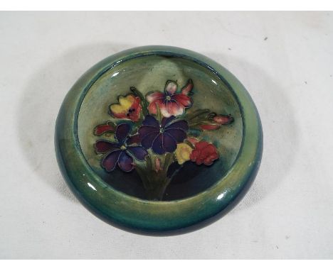 A Moorcroft Pottery inverted bowl decorated in the Spring Flowers pattern, 11.5cm (diam) - Est £50 - £80