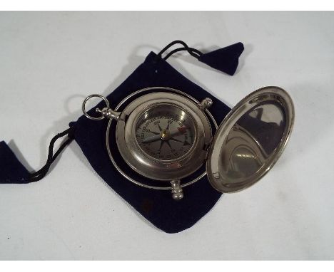 A white metal compass with single hinge protective cover, 11cm (d) with a cloth protective case