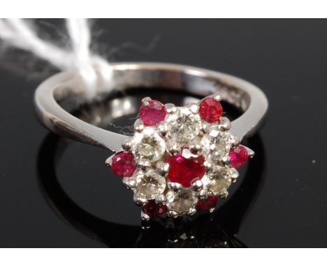 An 18ct white gold ruby and diamond set flower head  cluster ring, size M