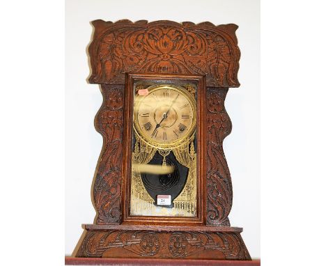 A late 19th century oak cased mantel clock by the Ansonia clock Company, having paper dial with Roman numerals and eight day 