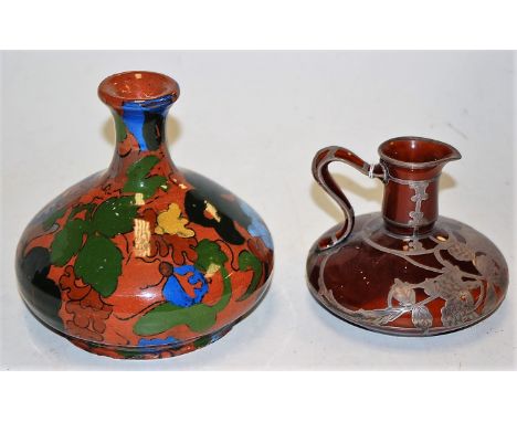 An early 20th century Lenox pottery jug of squat circular form having silver overlay with engraved floral decoration and shie