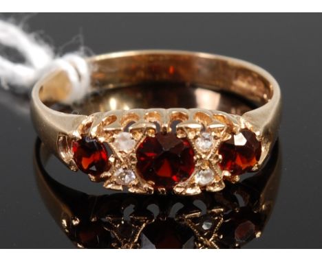 An Edwardian style three garnet dress ring, the stones each dispersed with a pair of small old cut diamonds, 2.4g, size Q