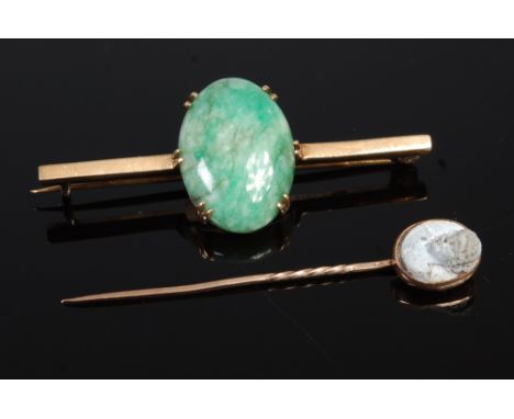 A 9ct gold cabochon jade set bar brooch; together with a yellow metal and carved hardstone set pin brooch (2) 