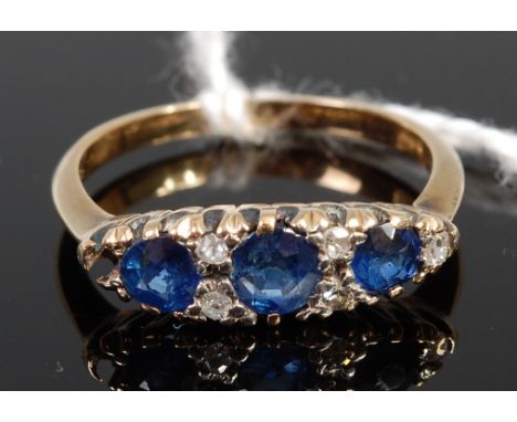 An 18ct gold, sapphire and diamond ring, the three oval cut sapphires each dispersed with twin small old cut diamonds, size N