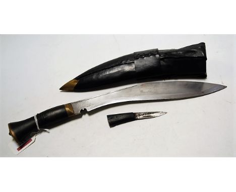 A tourist kukri, having curved steel blade and brass mounted handle, in leather scabbard 