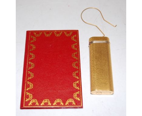 A Cartier of Paris textured gilt pocket cigarette lighter No. 29905J with red leather sleeve   Condition Report / Extra Infor