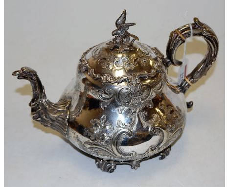 A Victorian silver plated teapot the hinged cover with bird knop finial, having all over floral and C scroll decoration by Ro