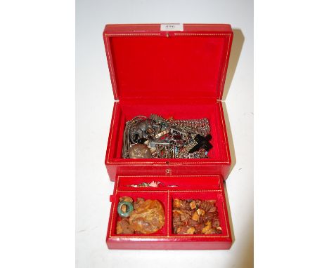 A small leather clad jewellery box and contents to include pocket cigar cutter, paste set costume jewellery, loose amber boul
