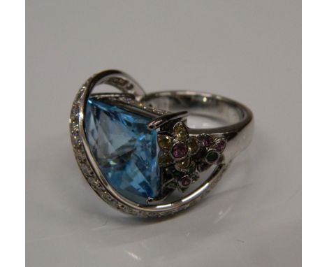 An 18 K white gold and blue topaz ring, set with diamonds and multi gem floral decoration. Ring size N/O (16.5 grammes total 